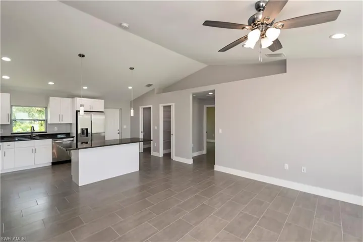 Kitchen featuring a center island, dark countertops, visible vents, appliances with stainless steel finishes, and a sink