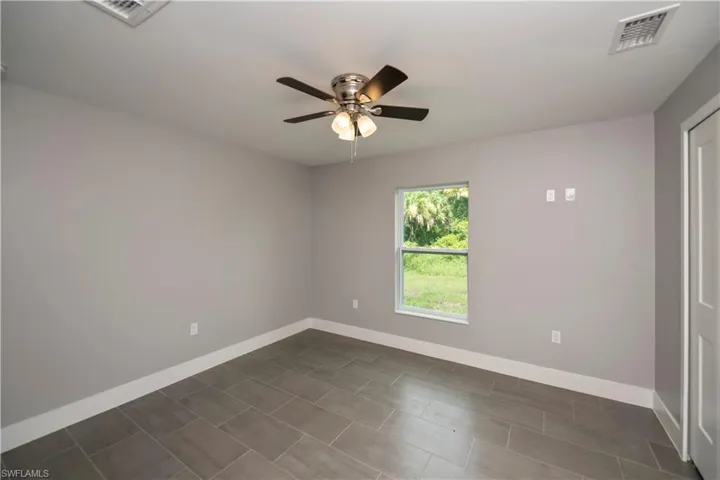 Spare room featuring baseboards, visible vents, and a ceiling fan