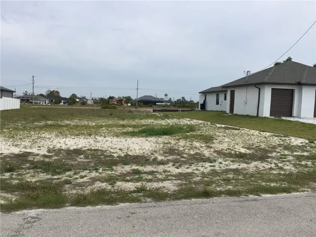 View of lot and brand new house to the right