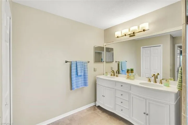 Full bathroom with double vanity and a closet
