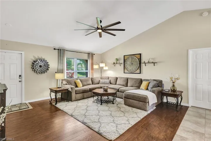 Living area featuring wood finished floors, vaulted ceiling, and ceiling fan