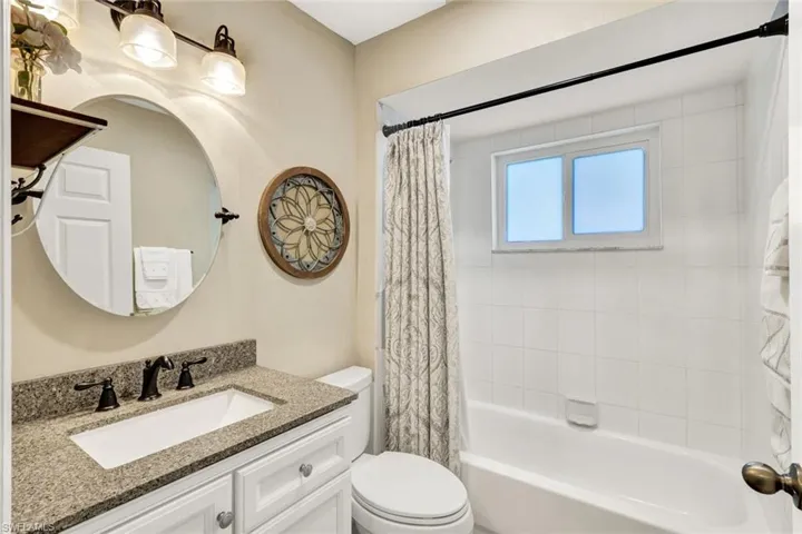 Bathroom featuring vanity and shower / bath combo with shower curtain