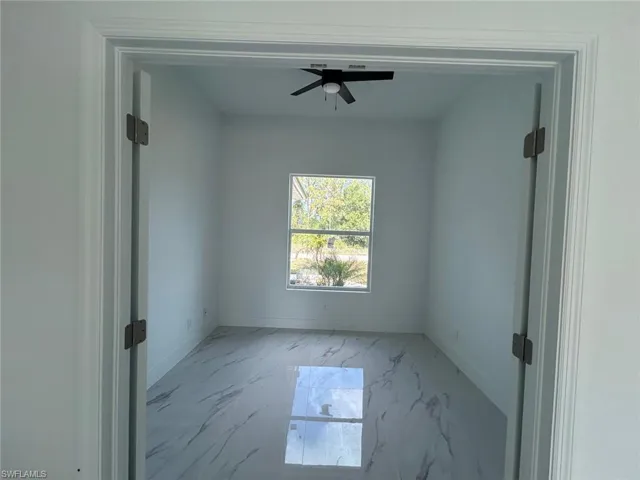 Unfurnished room featuring marble finish flooring and a ceiling fan