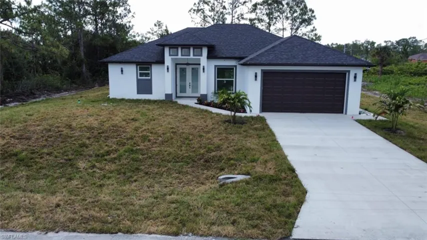 View of front of home featuring french doors, roof with shingles, an attached garage, stucco siding, and concrete driveway