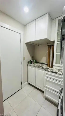 Kitchen featuring light tile patterned floors and white cabinets