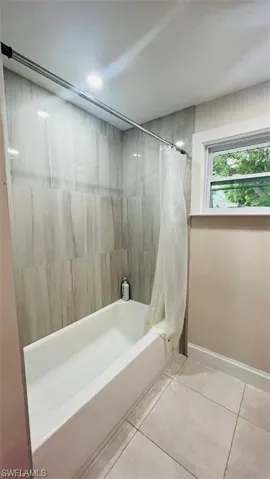 Full bathroom with tile patterned flooring and shower / bath combo