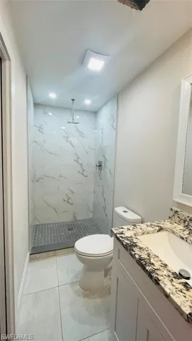 Full bath with vanity and a marble finish shower