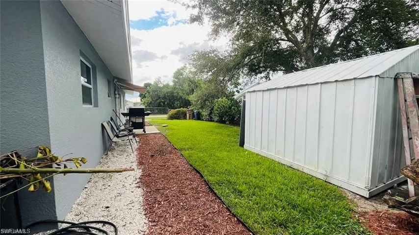 View of grassy yard with a shed