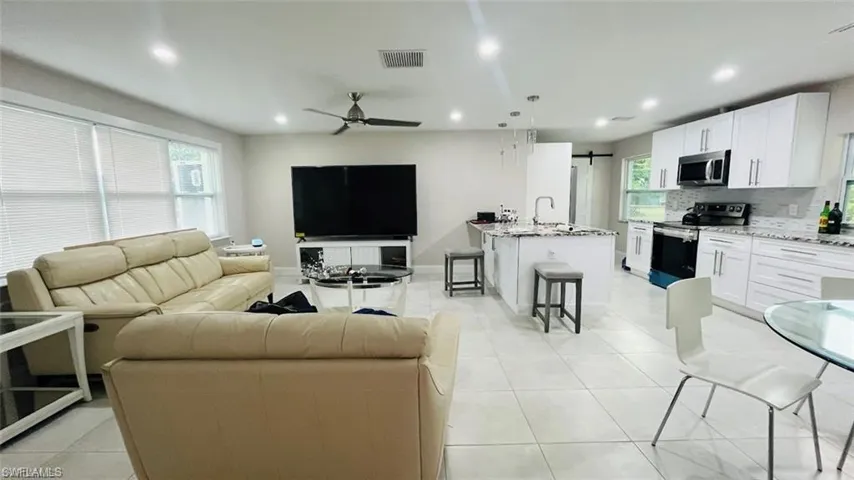 Living room with a ceiling fan, recessed lighting, plenty of natural light, and light tile patterned floors