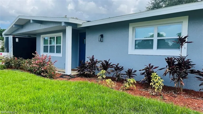 View of front facade with stucco siding and a front lawn