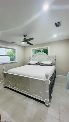 Bedroom with light tile patterned floors and a ceiling fan