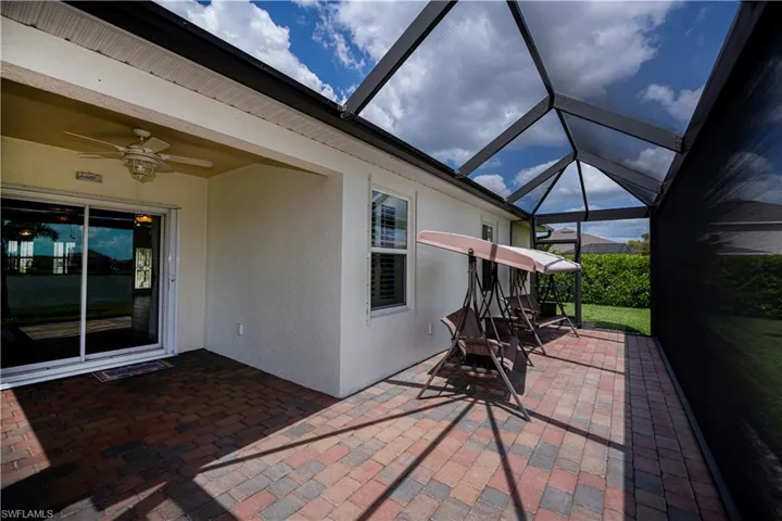 View of patio featuring  lanai and a ceiling fan