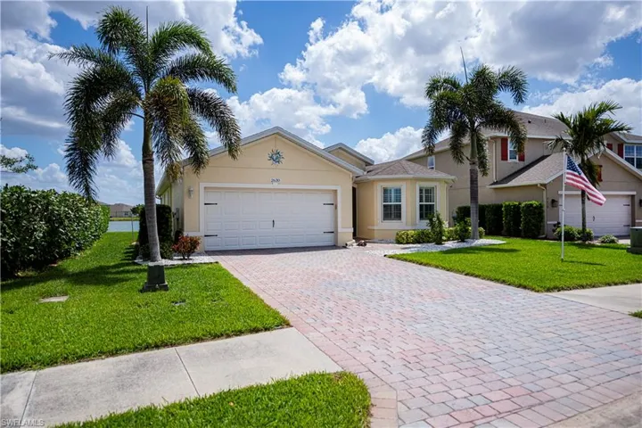 View of front with  lawn, decorative driveway, stucco siding, and an attached garage