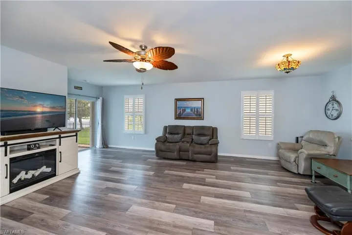 Living area with baseboards, wood finished floors, and a ceiling fan