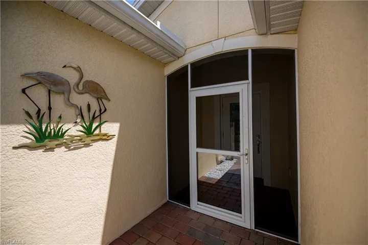 Property entrance with enclosed front porch screened door