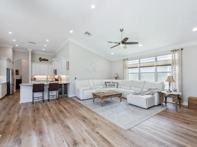 Living room with ceiling fan, crown molding, and light hardwood / wood-style flooring