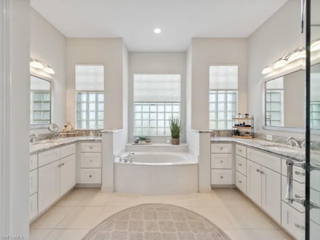 Bathroom featuring a washtub, tile patterned floors, and double sink vanity