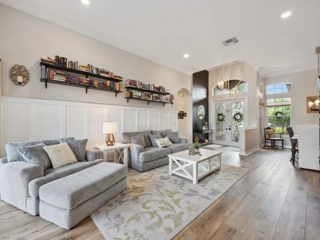 Living room with ornamental molding and light wood-type flooring