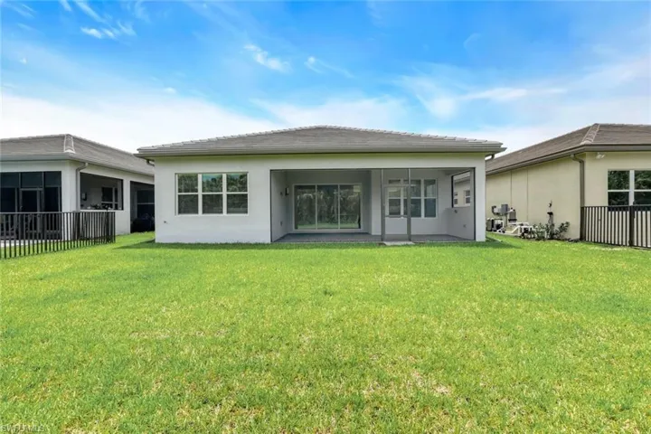 Back of property featuring a sunroom and a yard