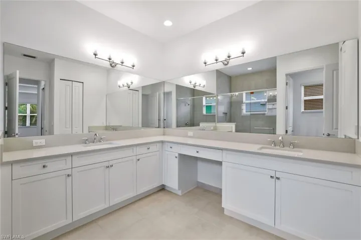 Master Bathroom with tile floors, an enclosed shower, large vanity, and double sink