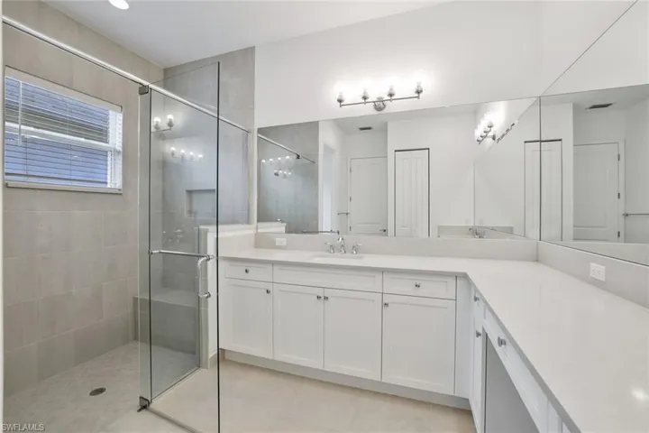 Master Bathroom with a shower with door, tile flooring, and vanity