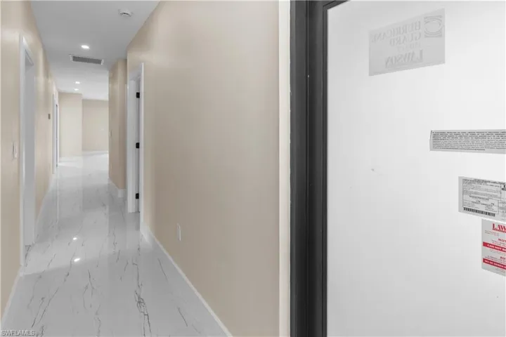 Hallway featuring recessed lighting, light marble finish flooring, and a heating unit