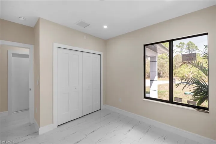 Unfurnished bedroom with light marble finish floors, a closet, and recessed lighting