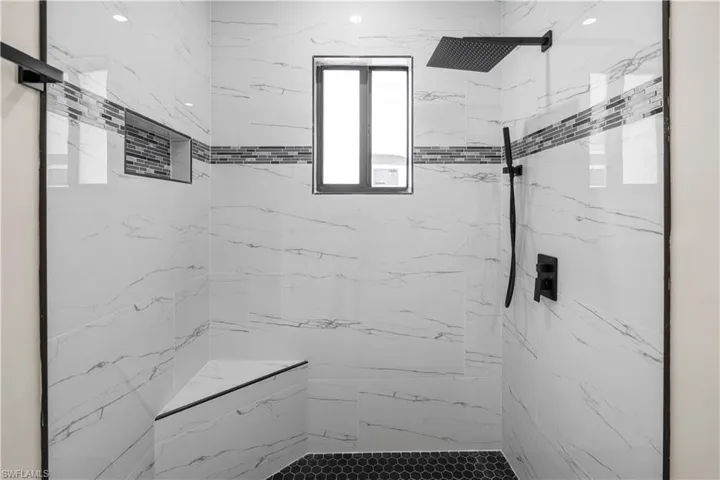 Full bath featuring a marble finish shower