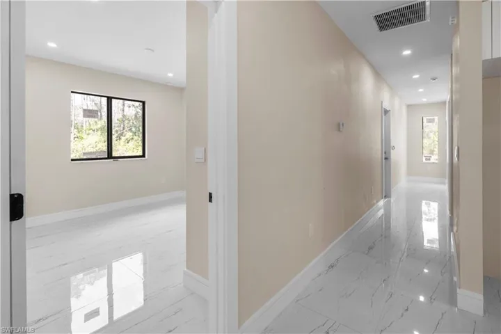 Corridor with recessed lighting and light marble finish flooring