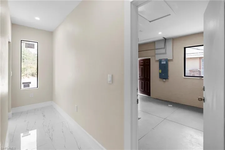 Corridor with electric panel and recessed lighting