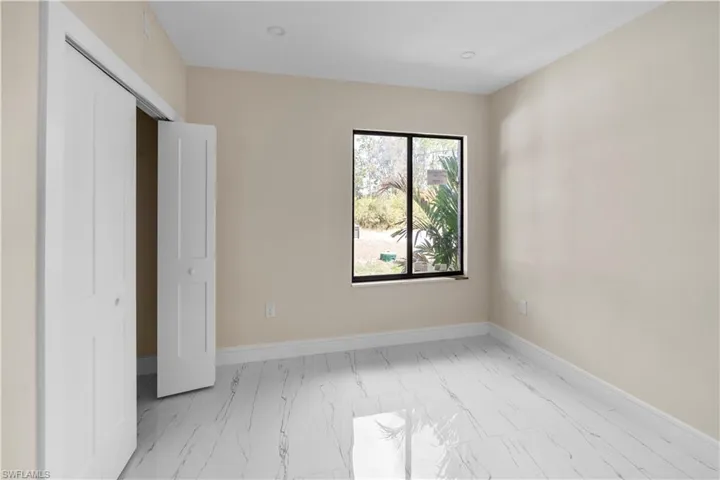 Unfurnished bedroom with light marble finish flooring and a closet