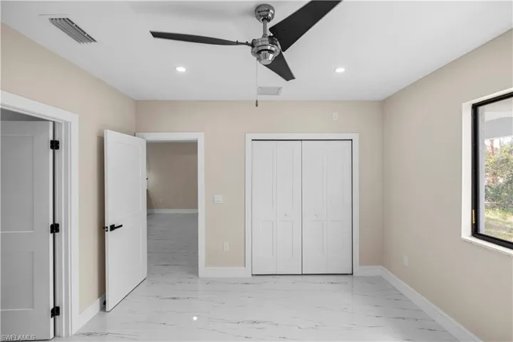 Unfurnished bedroom featuring light marble finish floors, ceiling fan, recessed lighting, and a closet