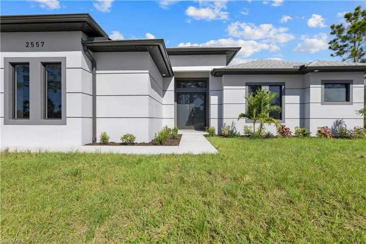Doorway to property featuring stucco siding and a yard