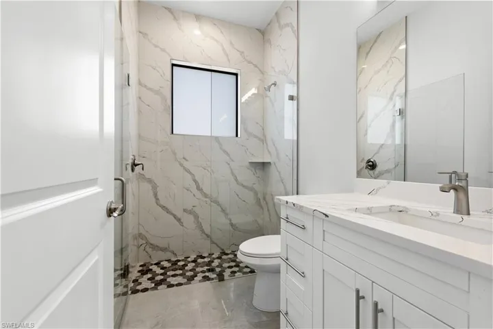 Full bathroom with vanity and a marble finish shower
