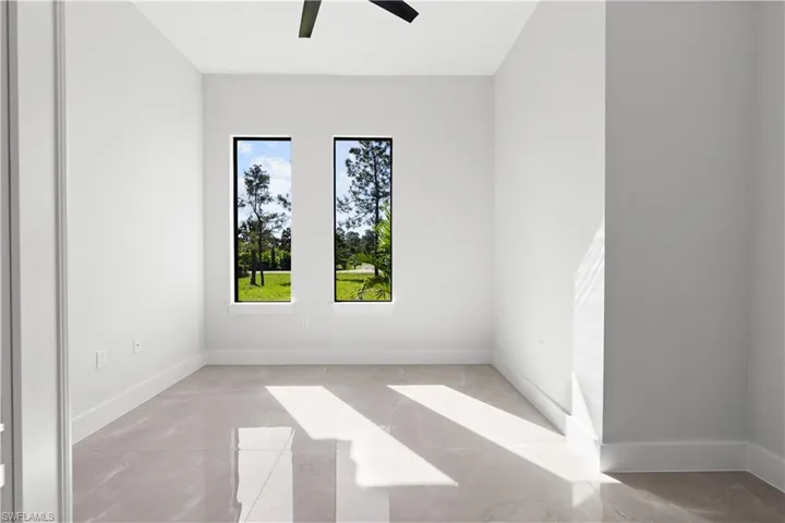 Spare room featuring a ceiling fan and baseboards