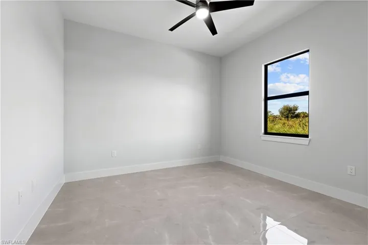 Spare room with a ceiling fan and baseboards