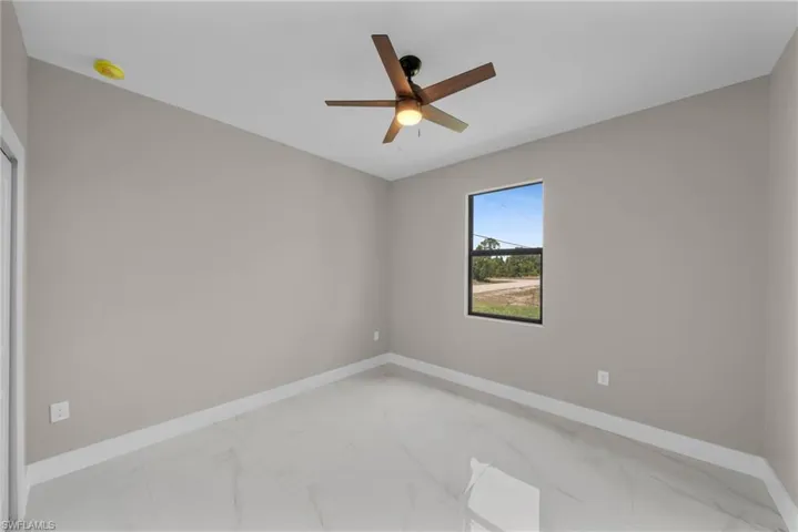 Spare room with light marble finish flooring and ceiling fan