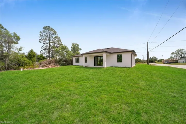 Rear view of property with a yard and stucco siding