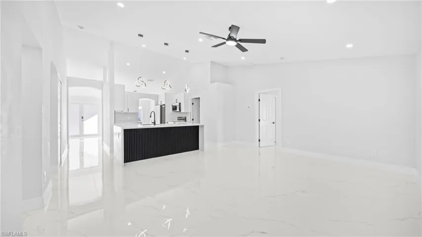 Unfurnished living room with high vaulted ceiling, recessed lighting, and ceiling fan