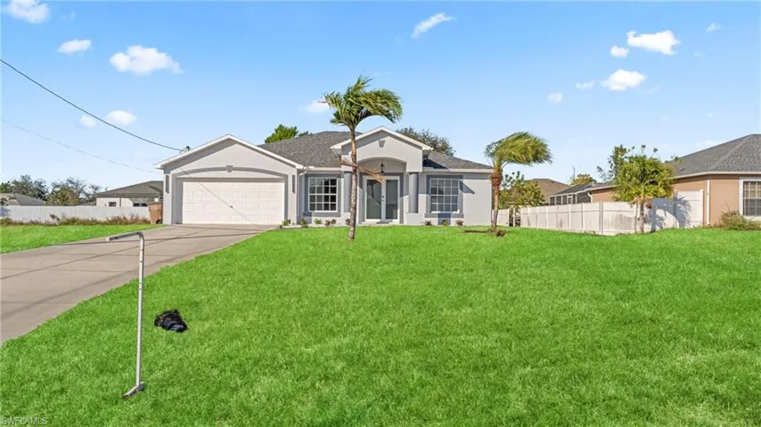 Ranch-style home featuring driveway, stucco siding, and a garage