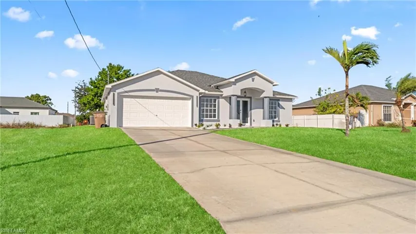 Ranch-style home featuring concrete driveway, stucco siding, and a garage