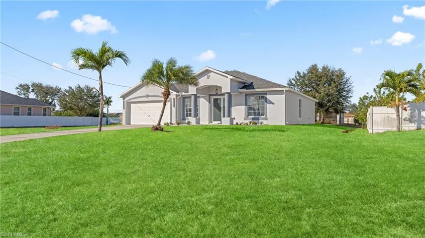 View of front of home featuring concrete driveway, stucco siding, and a garage