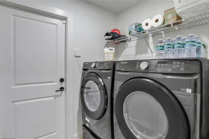 Laundry room inside with Samsung front load washer and dryer with storage drawers
