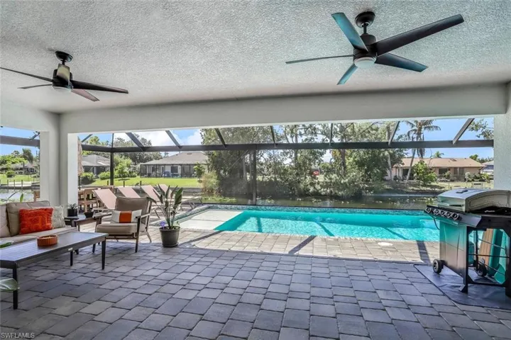 Panoramic Screened lanai featuring a saltwater heated pool with lights and paver patio, pool bath and canal view. South facing with sun all day.
