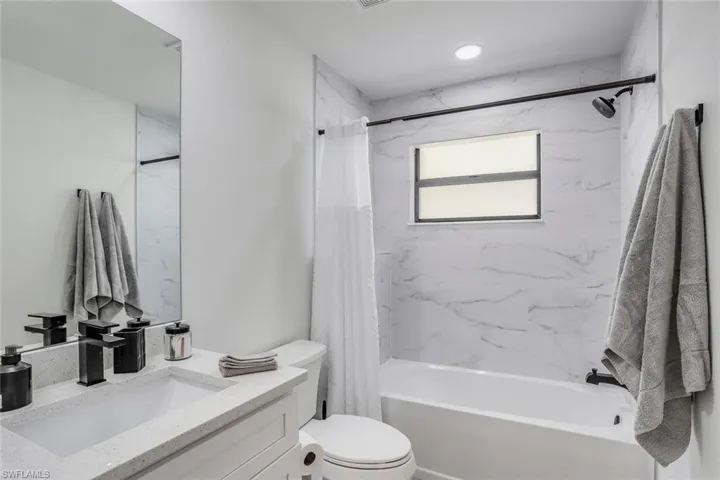 Guest bathroom shared by two guest rooms featuring shower/tub combo and natural light.