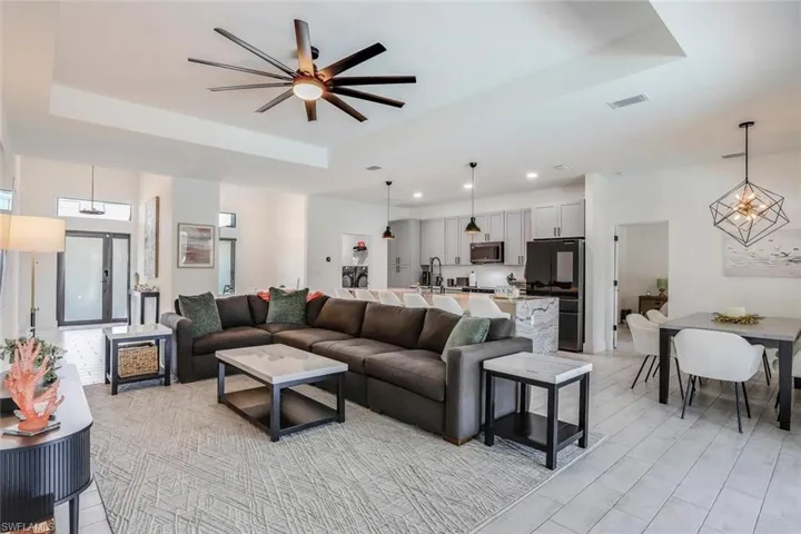 Open-concept living space featuring a tray ceiling with a ceiling fan, Perfect to enjoy family and hosting while cooking!
