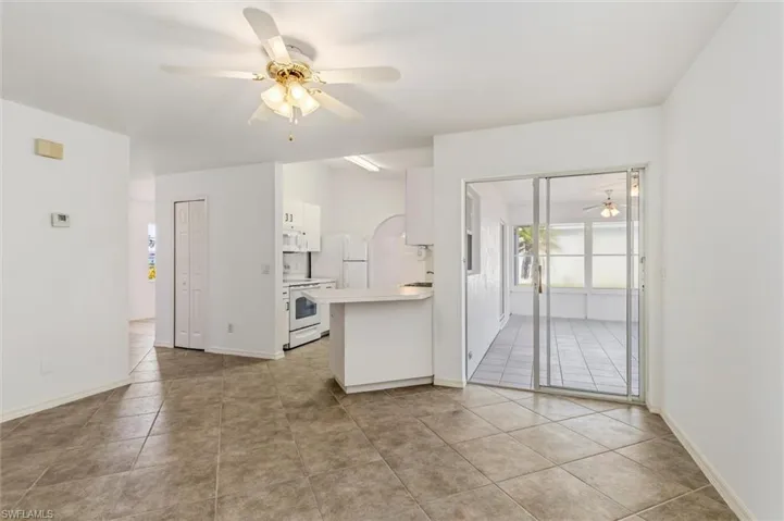 Open-concept living area featuring neutral-toned tile flooring and white walls
