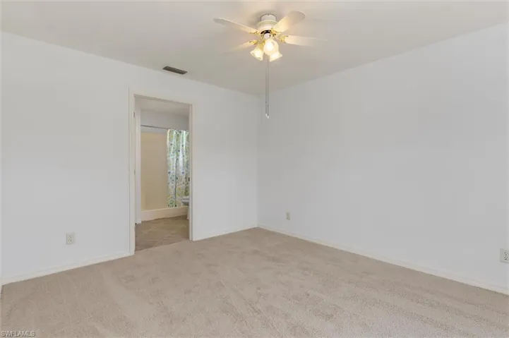 Carpeted room with white walls and a ceiling fan with integrated lighting
