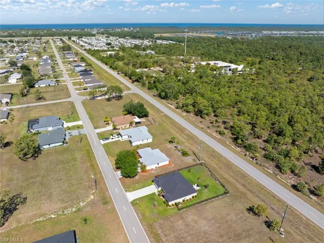 Aerial perspective showcasing a residential area with single-story homes and undeveloped lots