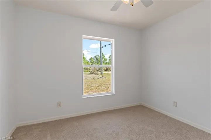 Room featuring neutral wall tones, white trim, and light-toned carpeting